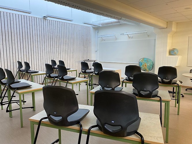 klassrum med uppställda stolar 